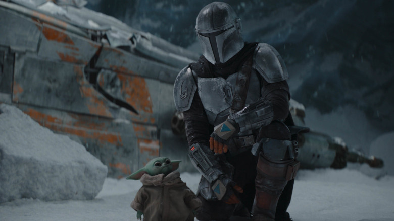 Baby Yoda (left) and the titular character of The Mandalorian (right) in a snowy environment.